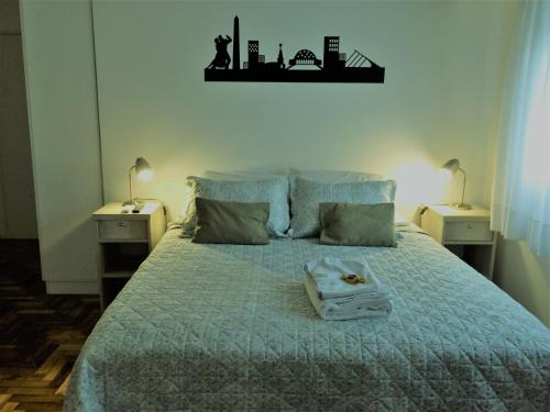 una camera con un letto con due comodini e due lampade di Luminoso Estudio a Buenos Aires