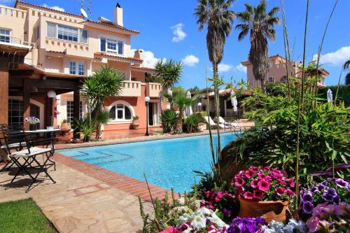 a pool in front of a house with flowers at Oasis Pool House by GHH in Lagonissi