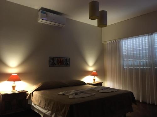 a bedroom with a bed with two lamps and a window at Quebrada Mansa in Nono