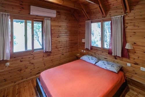 een slaapkamer met een bed in een blokhut bij Ronit and Mario in Abirim