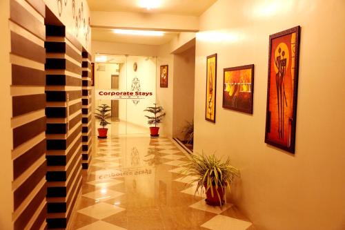 a hallway with potted plants in a building at Downtown Business Hotel in Singapperumālkovil