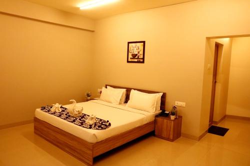a bedroom with a bed in a room at Downtown Business Hotel in Singapperumālkovil