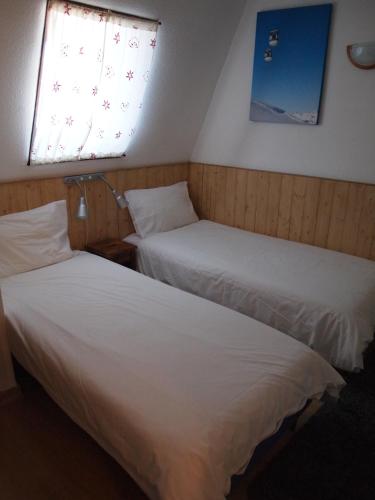 deux lits dans une chambre avec deux fenêtres dans l'établissement Alpine Hideout, à Les Deux Alpes