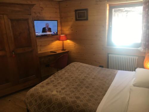 a bedroom with a bed and a tv on a wall at B&B Gressoney in Gressoney-la-Trinité