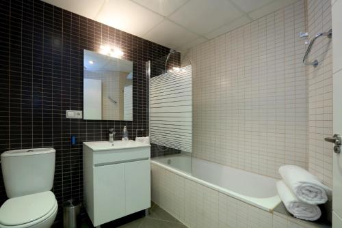 W łazience znajduje się toaleta, wanna i umywalka. w obiekcie Reino de Valencia Apartments w Walencji