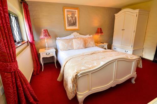 a bedroom with a large white bed and two lamps at The Roundabout Hotel in Pulborough