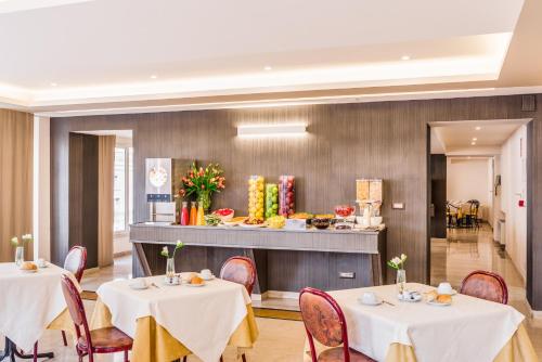 a dining room with two tables and a buffet at Raeli Hotel Siracusa in Rome