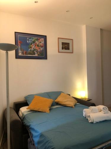 a bedroom with a blue bed with two pillows at Studio Saint Anne in Montpellier