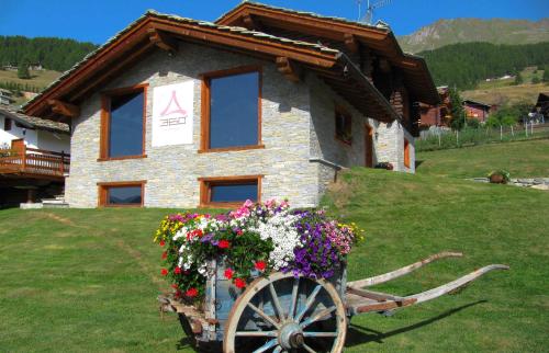 a house with a flower cart in front of it at Residence Lo Peyo in Champoluc