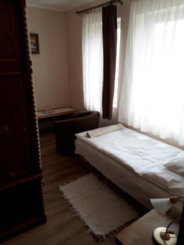 a bedroom with a bed and a large window at Szilvia Panzió Gyomaendrőd in Gyomaendrőd