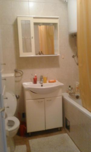 a white bathroom with a sink and a toilet at Apartman na Savini in Herceg-Novi