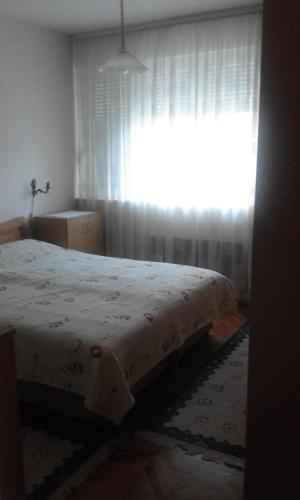 a bedroom with a bed in front of a window at Apartman na Savini in Herceg-Novi