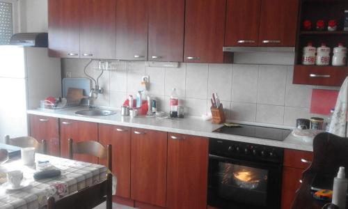 a kitchen with wooden cabinets and a stove at Apartman na Savini in Herceg-Novi