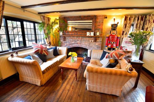 a living room with two couches and a fireplace at The Roundabout Hotel in Pulborough