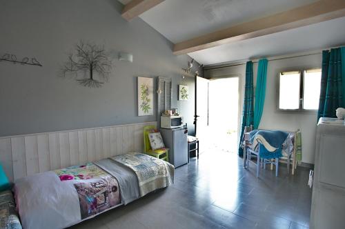 ein Schlafzimmer mit einem Bett und einem Tisch sowie eine Küche in der Unterkunft La Bastide des Sources in Le Castellet