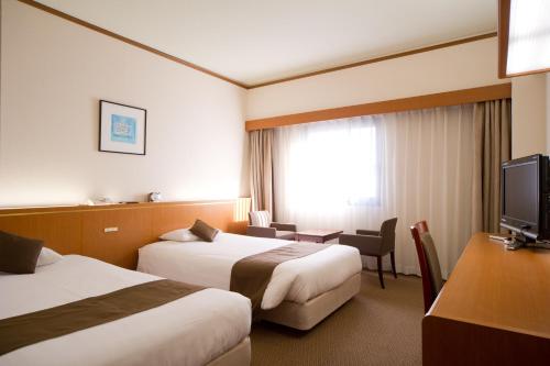 Habitación de hotel con 2 camas y TV en Daiichi Inn Ikebukuro, en Tokio