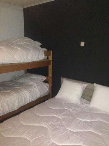 a bedroom with two bunk beds with white sheets at James D in De Haan