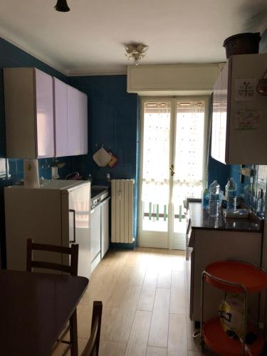 a kitchen with blue walls and a kitchen with white appliances at A bright central flat at Limone Piemonte in Limone Piemonte