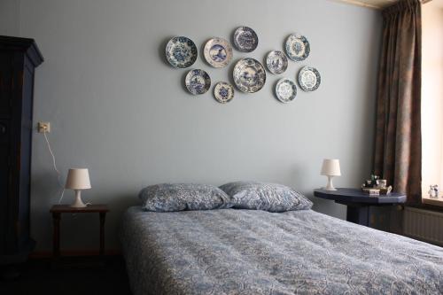 um quarto com uma cama com pratos na parede em Logerenbijonsz em Berghem