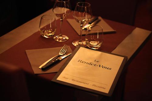 a table with wine glasses and a menu on it at Ancolies Val Thorens in Val Thorens