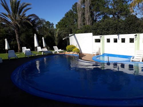 a large swimming pool with chairs and a swimming pool at Hotel La Posta del Dayman in Termas del Daymán