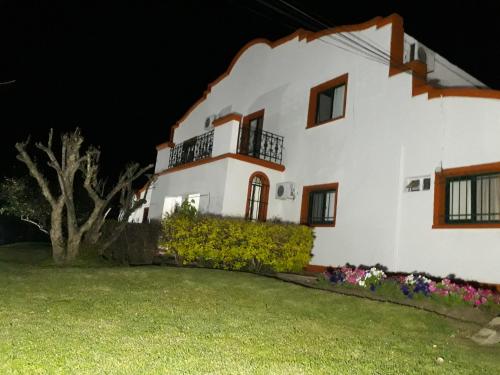 a white house with a yard at night at Hotel La Posta del Dayman in Termas del Daymán