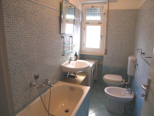a bathroom with a tub and a sink and a toilet at Appartamento Dionea in Grado