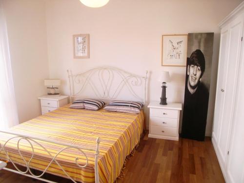 a bedroom with a bed and a painting of a man at Appartamento Dionea in Grado