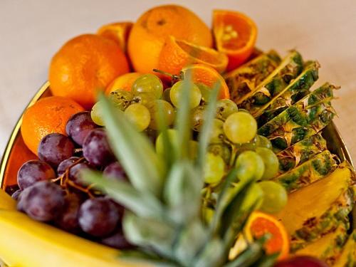 a plate of fruit on a table with grapes and oranges at Katarzynka in Boleścin