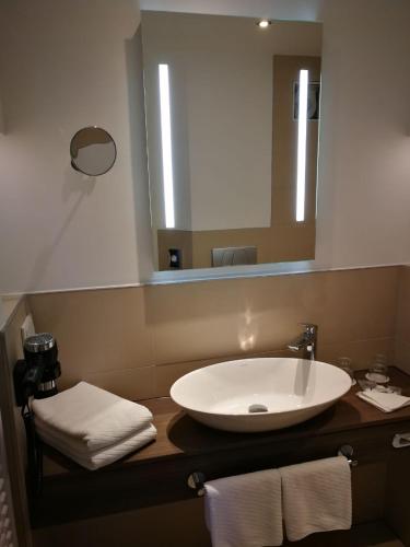 a bathroom with a white sink and a mirror at Ringhotel Villa Margarete in Waren