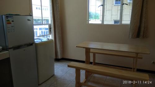 a small kitchen with a table and a refrigerator at Alpha Villa in Flic-en-Flac