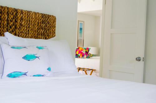 a white bed with fish on the pillows at Bequia Plantation Hotel in Bequia