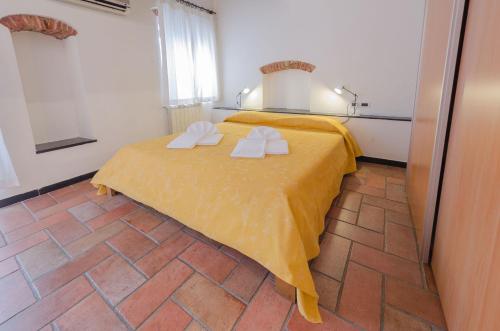 a bedroom with a yellow bed with towels on it at Casa del Sole in Finale Ligure
