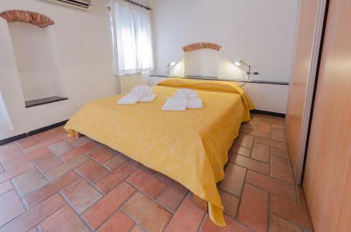 フィナーレ・リーグレにあるCasa del Soleのベッドルーム1室(黄色いベッド1台、タオル付)