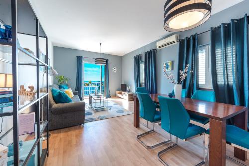 uma sala de jantar com paredes azuis e uma mesa e cadeiras em Summer Experience Apartment em Mlini
