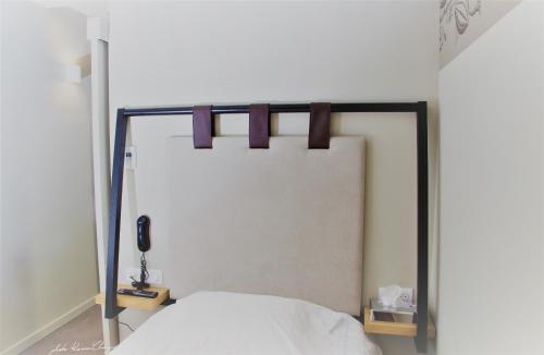 a bedroom with a white bed and a phone at Aigle d'Or - Strasbourg Nord in Reichstett