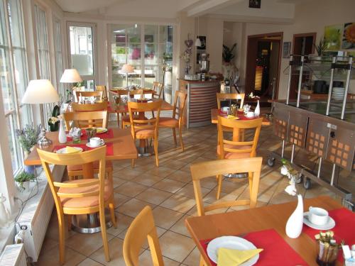 a restaurant with wooden tables and chairs in a room at Burghotel Münzenberg in Münzenberg