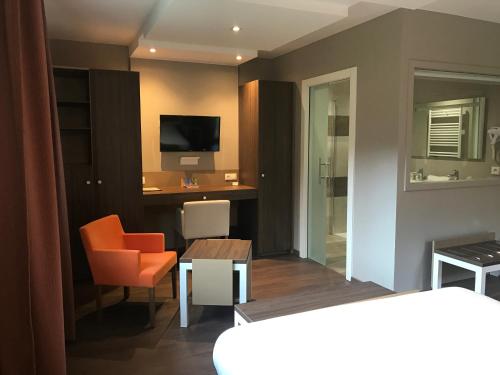 a living room with a desk and a television at Hôtel les Bergeronnettes in Champagneux