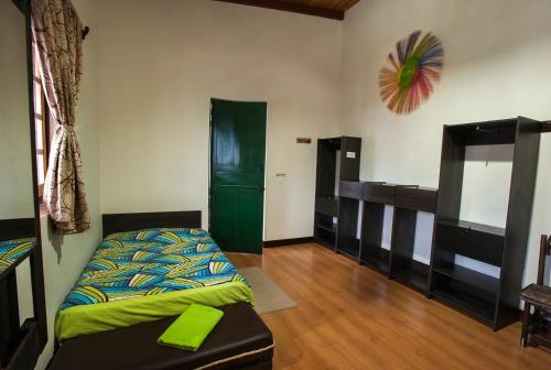 a bedroom with a bed and a green door at Casa Hospedaje La Bohemia in Pasto