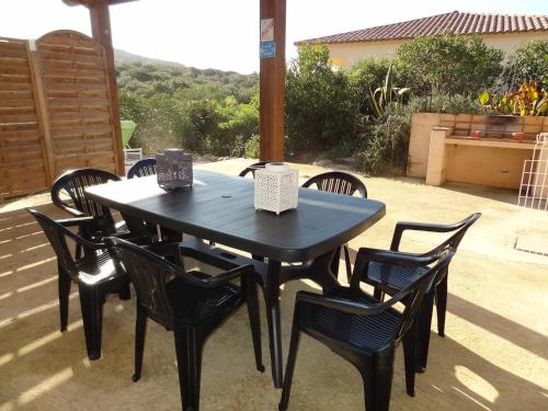 einen schwarzen Tisch und Stühle auf einer Terrasse in der Unterkunft Villa Les hauts de Benista in Porticcio