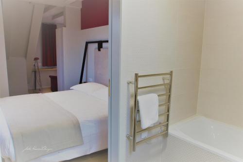 a bedroom with a white bed and a mirror at Aigle d'Or - Strasbourg Nord in Reichstett