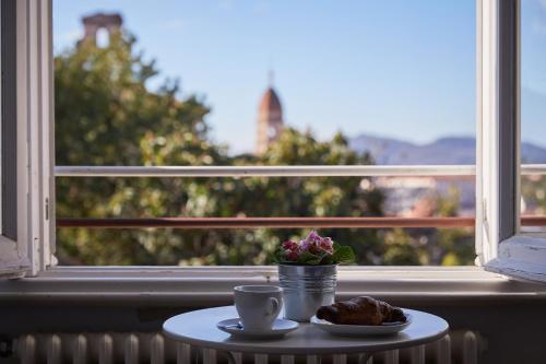 a cup of coffee sitting on a table next to a window at Cento Passi dal Duomo B&B in Arezzo
