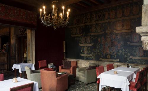 a dining room with tables and chairs and a chandelier at Hotel Duc De Bourgogne in Bruges
