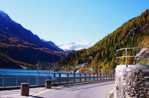 a bridge over a body of water next to a mountain at Ferienwohnungen Auhaus in Martello