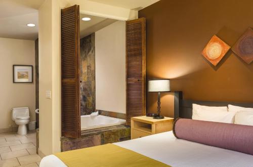 - une chambre d'hôtel avec un lit et une baignoire dans l'établissement WorldMark Phoenix - South Mountain Preserve, à Phoenix