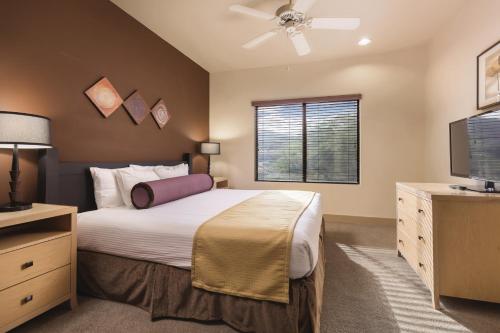 a bedroom with a bed and a flat screen tv at WorldMark Phoenix - South Mountain Preserve in Phoenix