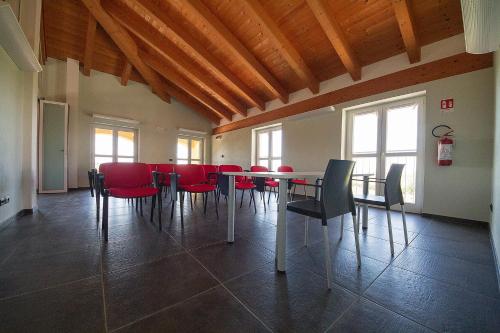 a dining room with a table and red chairs at Agriostello delle Langhe in Farigliano