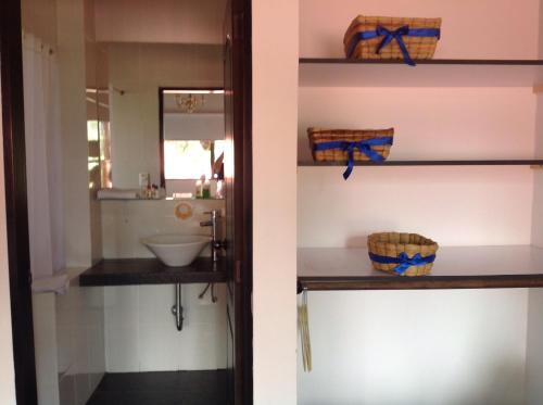 2 fotos de un baño con lavabo y espejo en Hotel Estancia Cucunuvaca, en Cucunubá