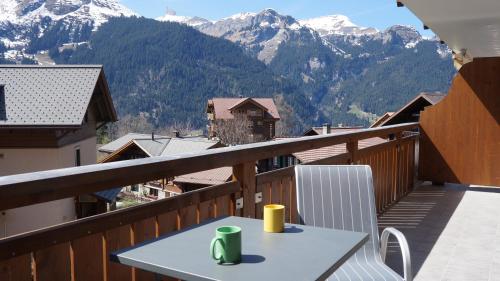 a table on a balcony with a view of mountains at Chalet Bella Vista 3 in Wengen