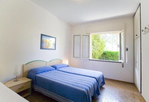 een slaapkamer met een blauw bed en een raam bij Angela in Bibione
